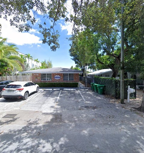 a parking lot in front of a brick house